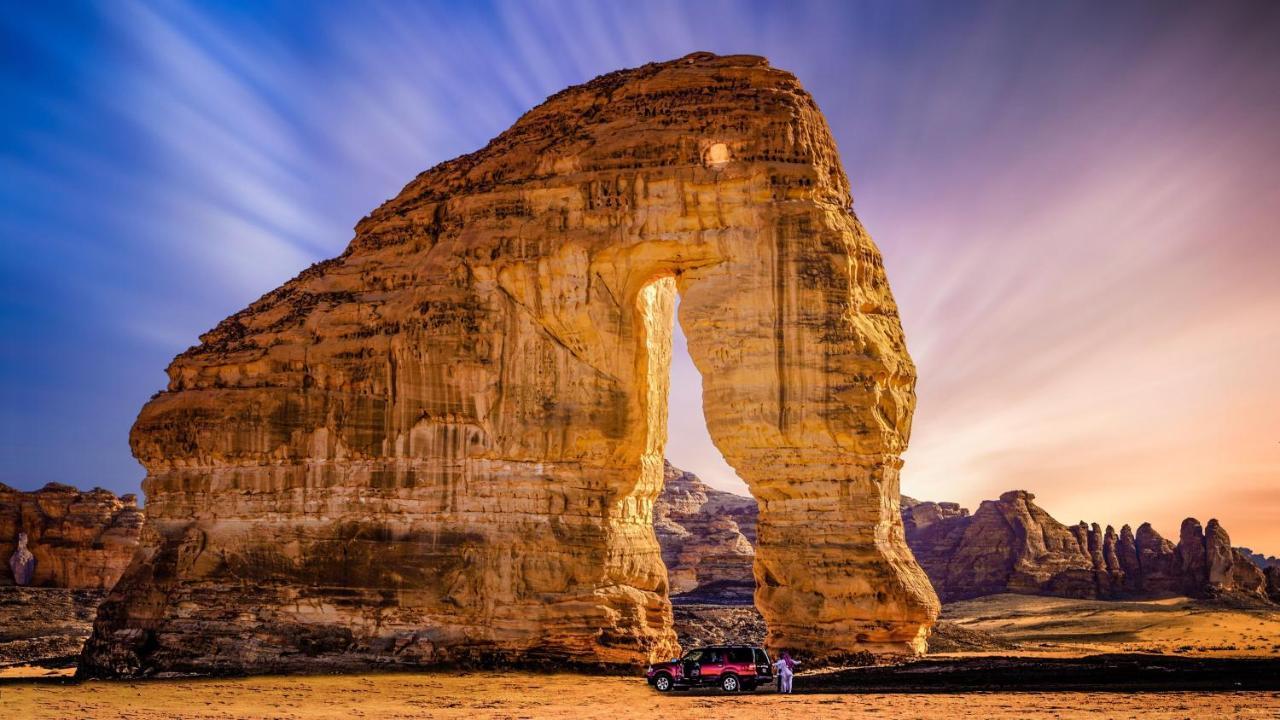 Hotel Intercontinental Dar Al Iman Madinah By Ihg Medina Exterior foto The photo depicts a striking rock formation, characterized by a large archway that has been sculpted by natural processes. The landscape around the formation features sandy terrain and rugged terrain, typical of desert environments. In the foreground